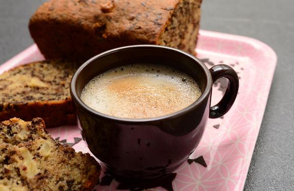 Tasse Kaffee und Rührkuchen auf Tablett
